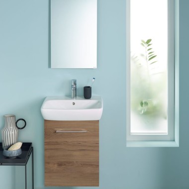 A wall-hung Renova Plan WC and a washbasin area attached to a light blue wall